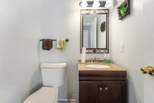 a bathroom with a toilet sink and mirror