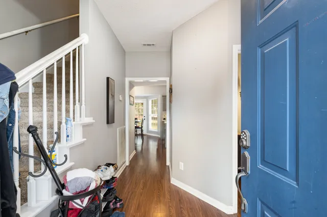 a view of a hallway with furniture and wooden floor