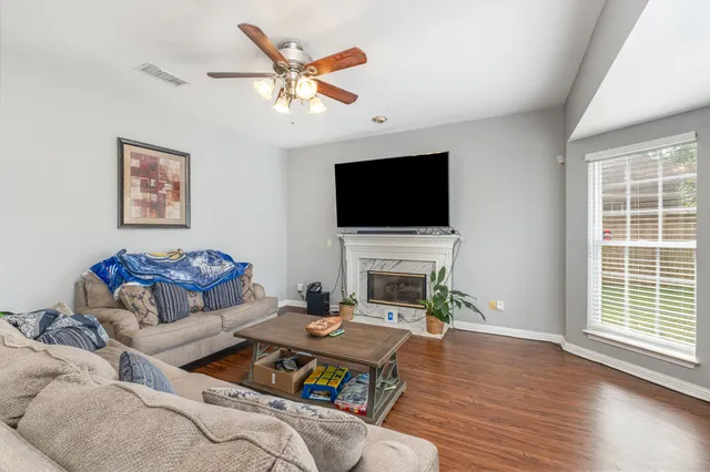 a living room with furniture a flat screen tv and a fireplace