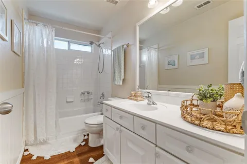 a spacious bathroom with a double vanity sink toilet mirror and bathtub