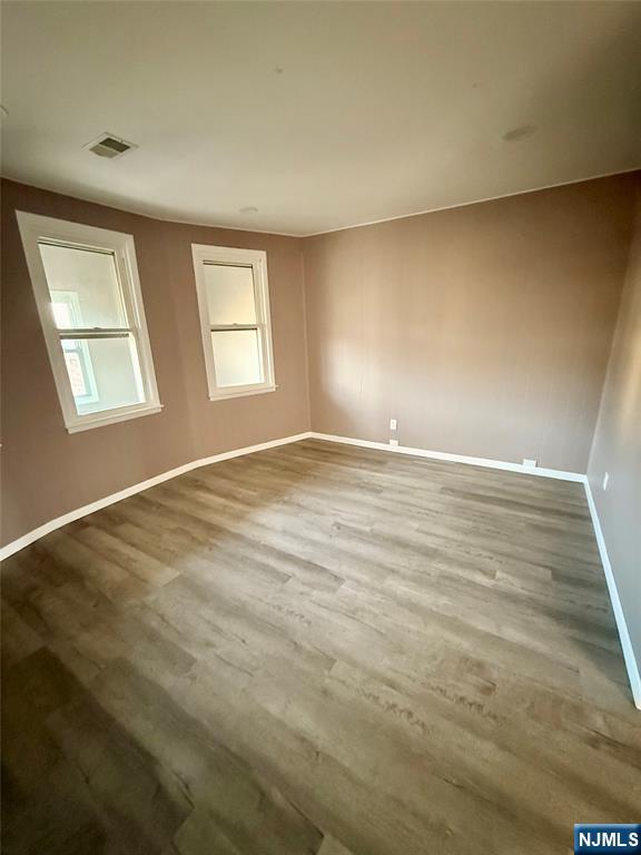 86 Hunter Street Lodi, NJ 07644 - Photo 11 of 15 a view of an empty room with wooden floor and a window