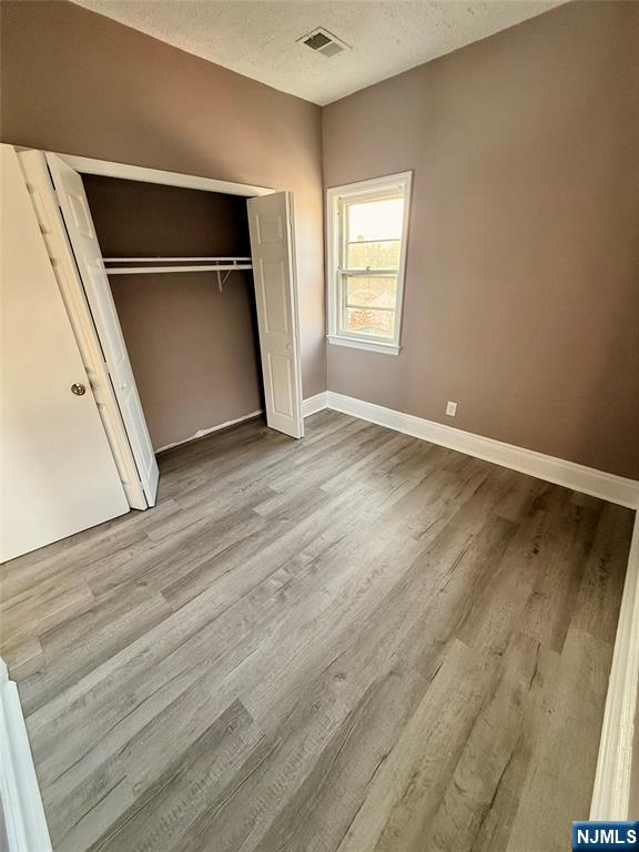 86 Hunter Street Lodi, NJ 07644 - Photo 6 of 15 an empty room with wooden floor and windows