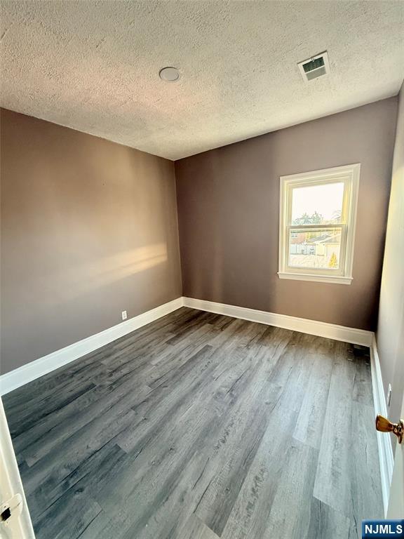 86 Hunter Street Lodi, NJ 07644 - Photo 7 of 15 an empty room with wooden floor and windows