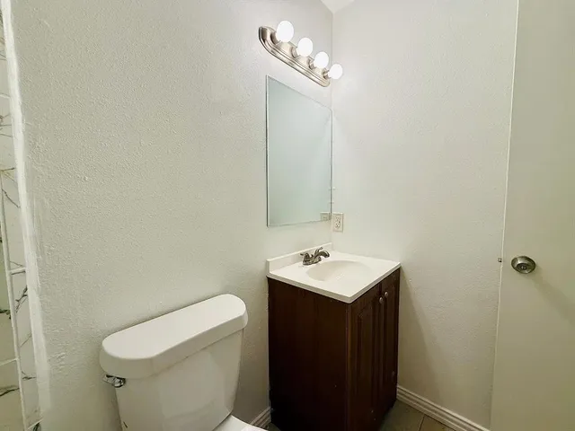 a bathroom with a toilet a sink and mirror