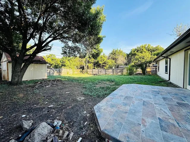 a view of a backyard with large trees