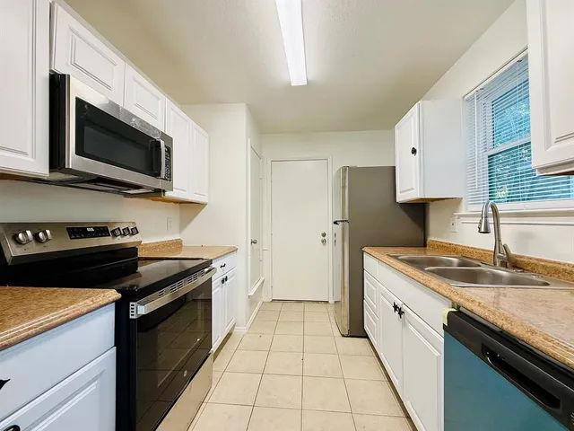 a kitchen with stainless steel appliances granite countertop a stove and a microwave