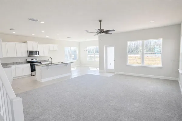 a view of an empty room with kitchen appliances and a window