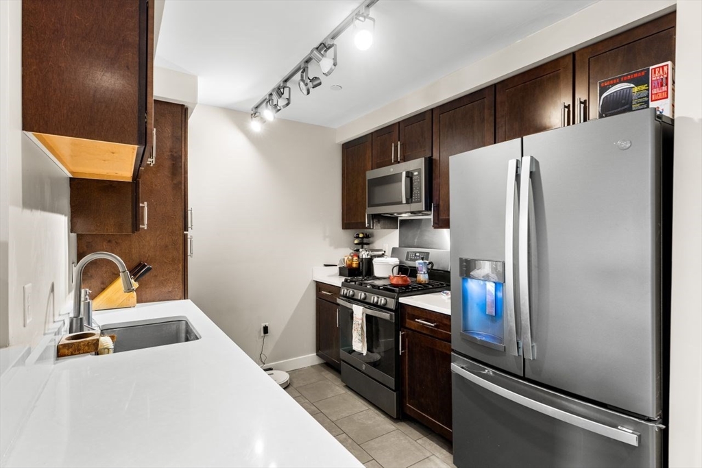130 John Street, Unit 459 Lowell, MA 01852 - Photo 13 of 42 a kitchen with stainless steel appliances a refrigerator sink and stove
