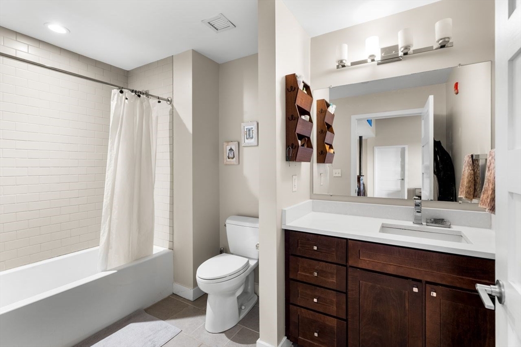 130 John Street, Unit 459 Lowell, MA 01852 - Photo 18 of 42 a bathroom with a toilet a sink and a large mirror