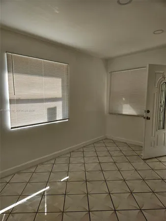 a view of a livingroom with a large window and wooden floor