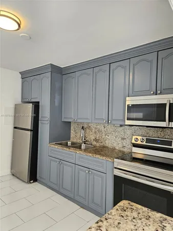 a kitchen with stainless steel appliances granite countertop a refrigerator sink and stove