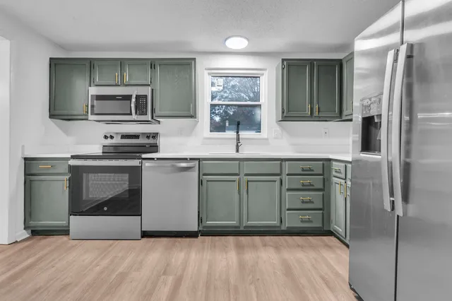 a kitchen with stainless steel appliances a refrigerator sink and stove