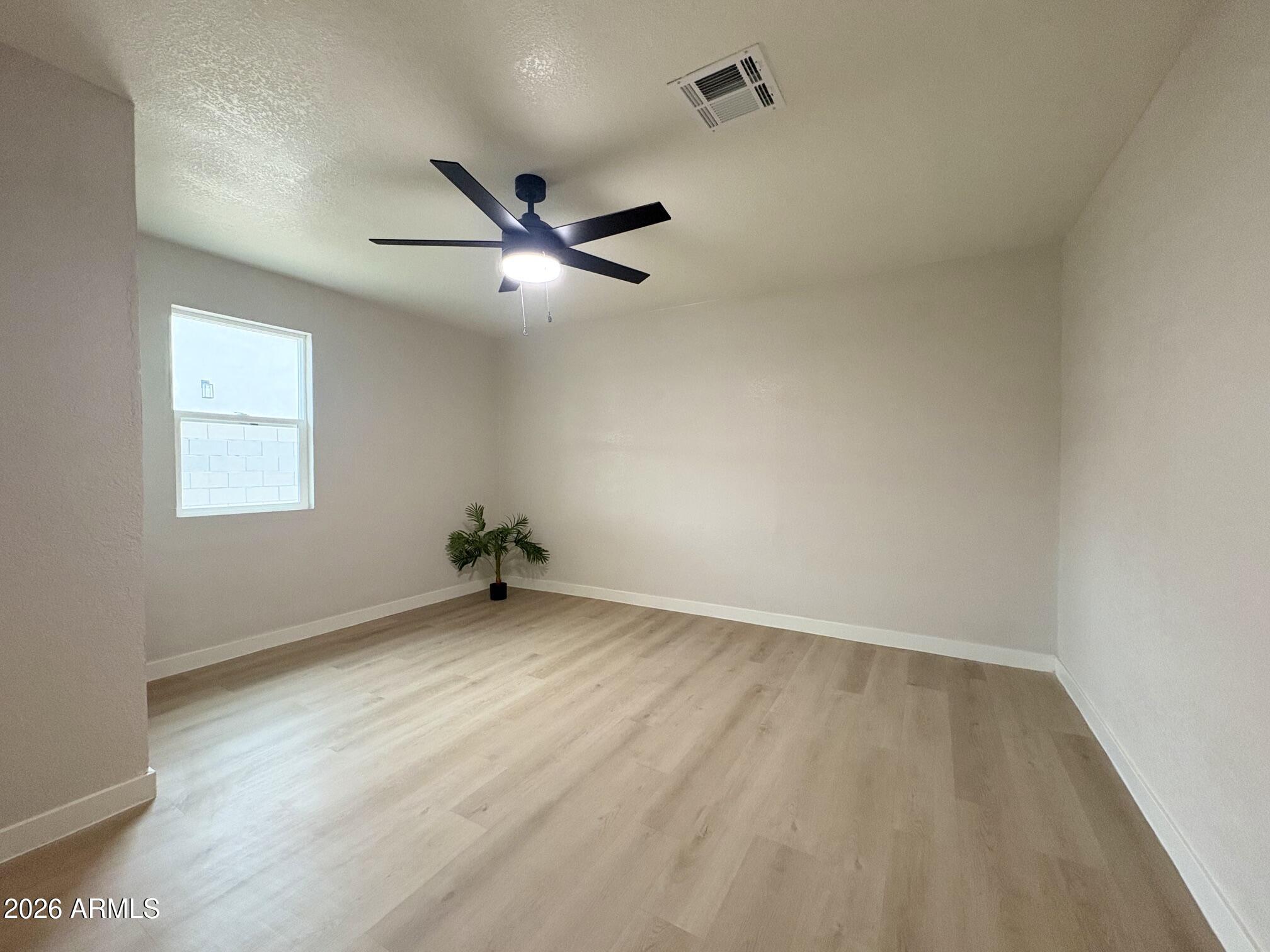 175 South Matilda Street Florence, AZ 85132 - Photo 10 of 16 an empty room with a window and a ceiling fan