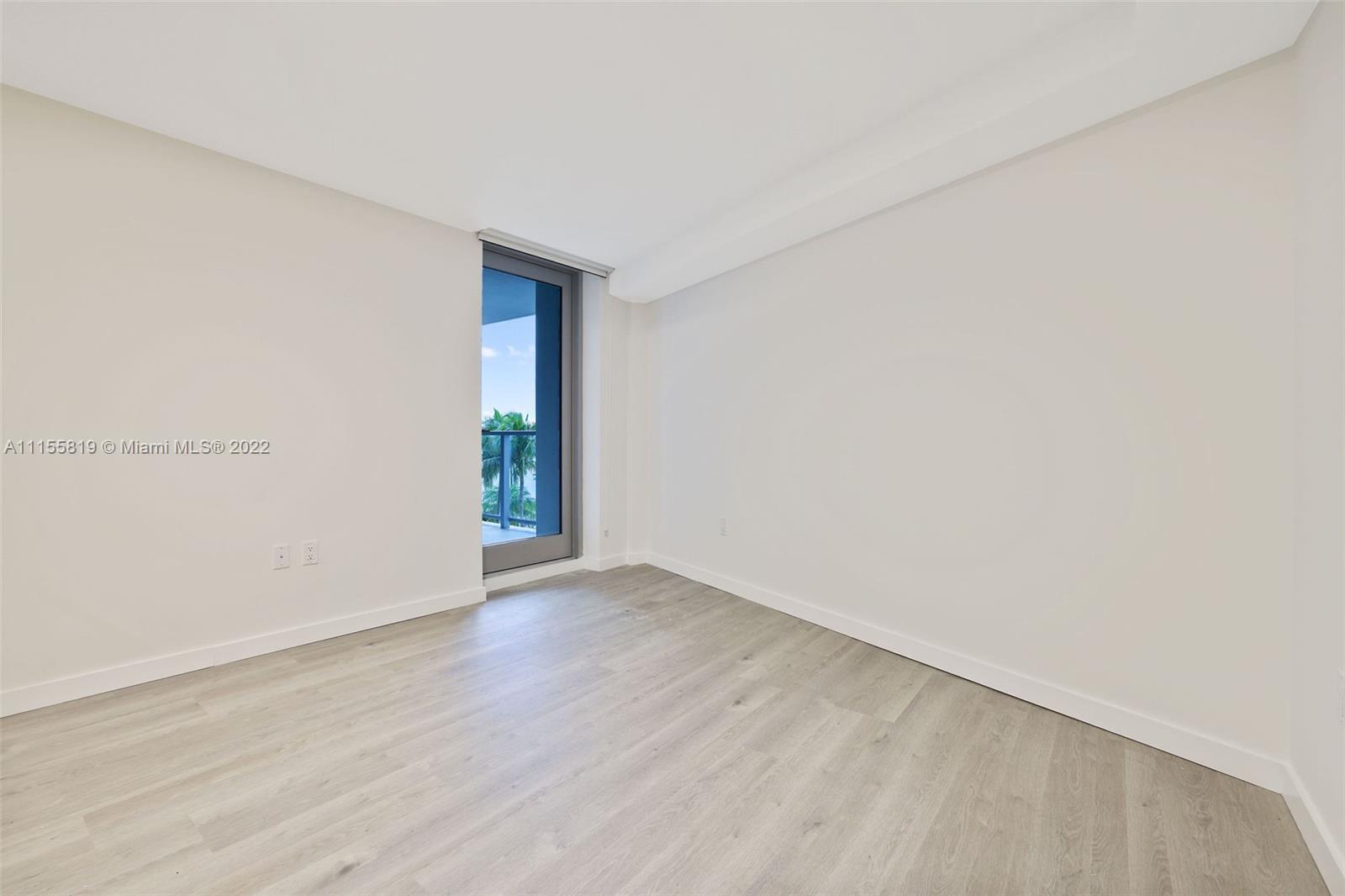 1504 Bay Road, Unit N1508 Miami Beach, FL 33139 - Photo 15 of 89 a view of an empty room with wooden floor and a window
