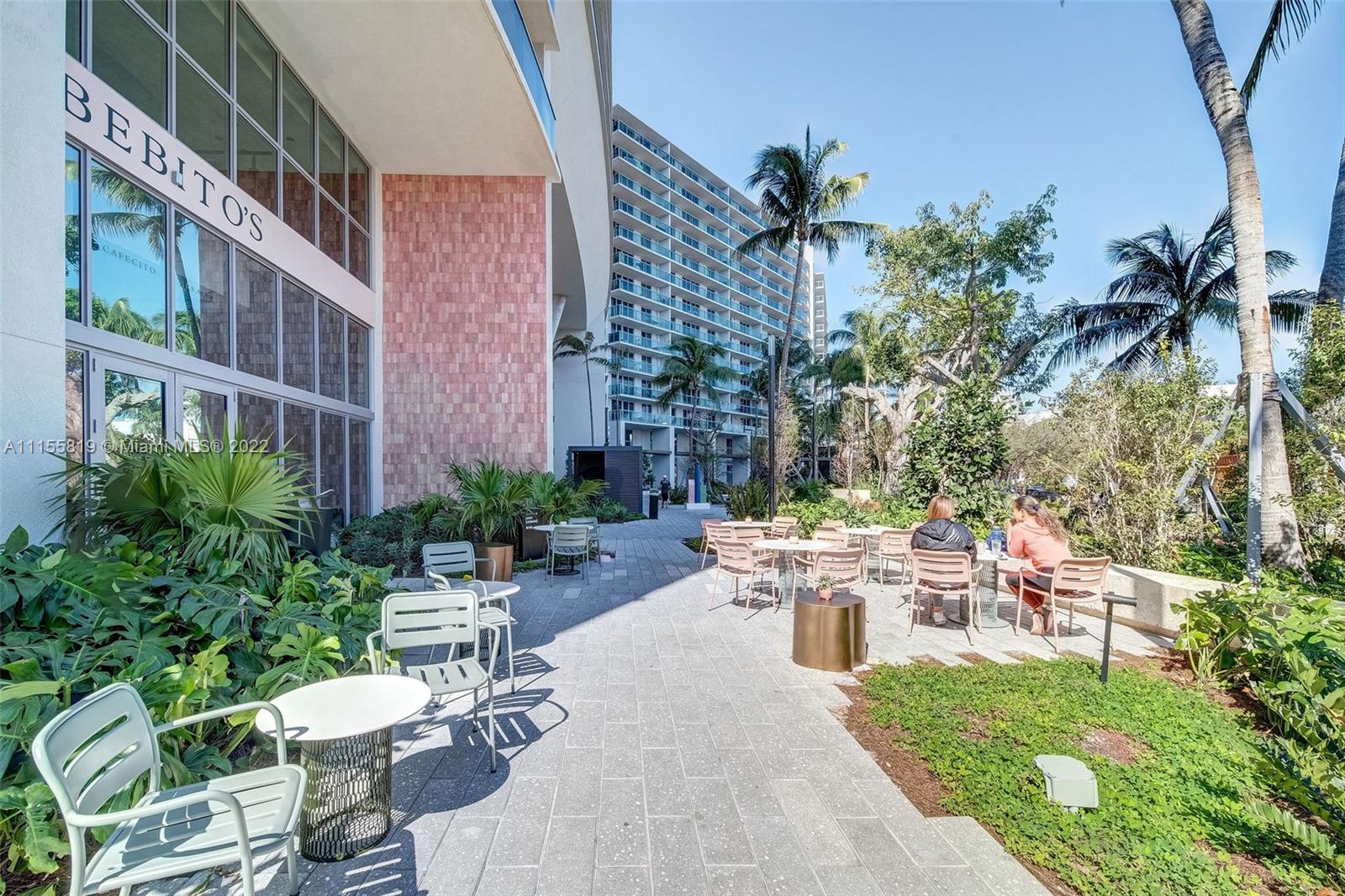 1504 Bay Road, Unit N1508 Miami Beach, FL 33139 - Photo 57 of 89 a view of a patio with table and chairs potted plants and palm tree