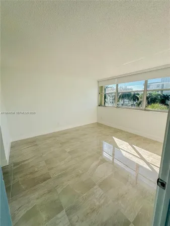 a bathroom with a granite countertop sink a toilet a mirror and shower