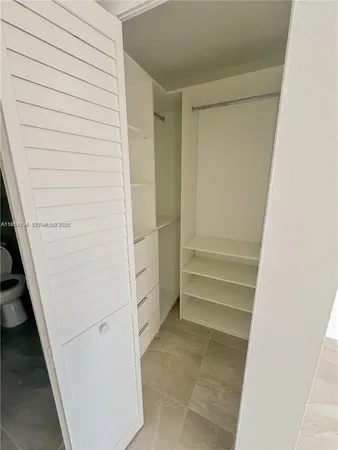 a bathroom with a granite countertop toilet a sink and a mirror