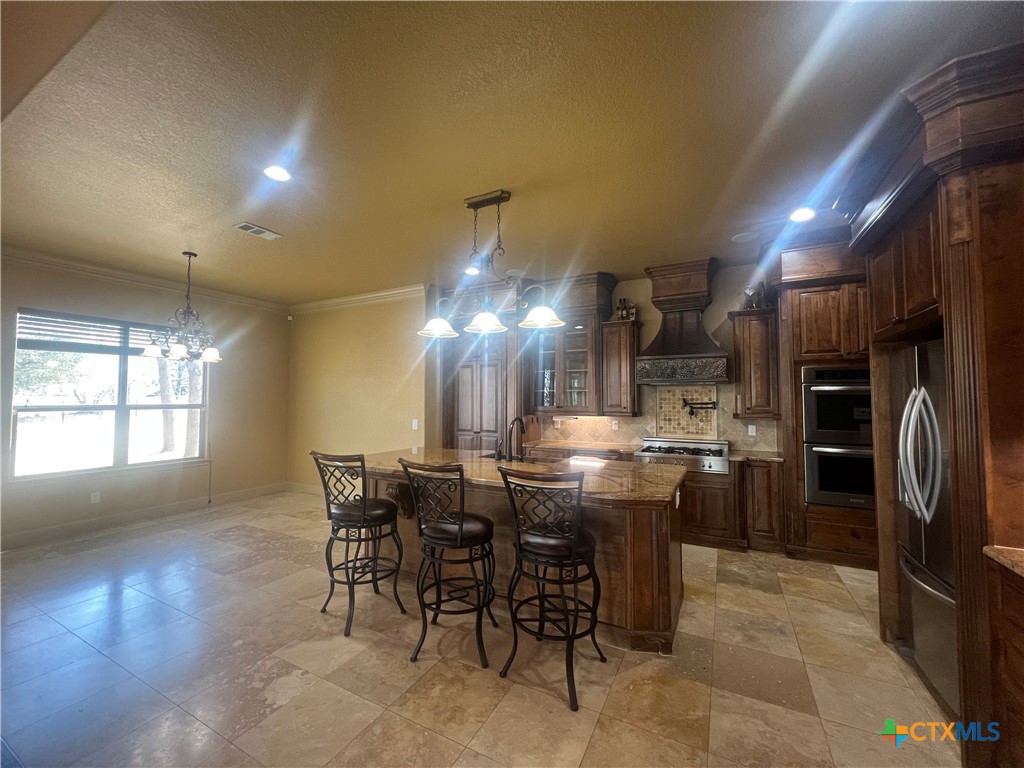 523 Messer Ranch Road Belton, TX 76513 - Photo 14 of 40 a kitchen with refrigerator a sink dining table and chairs