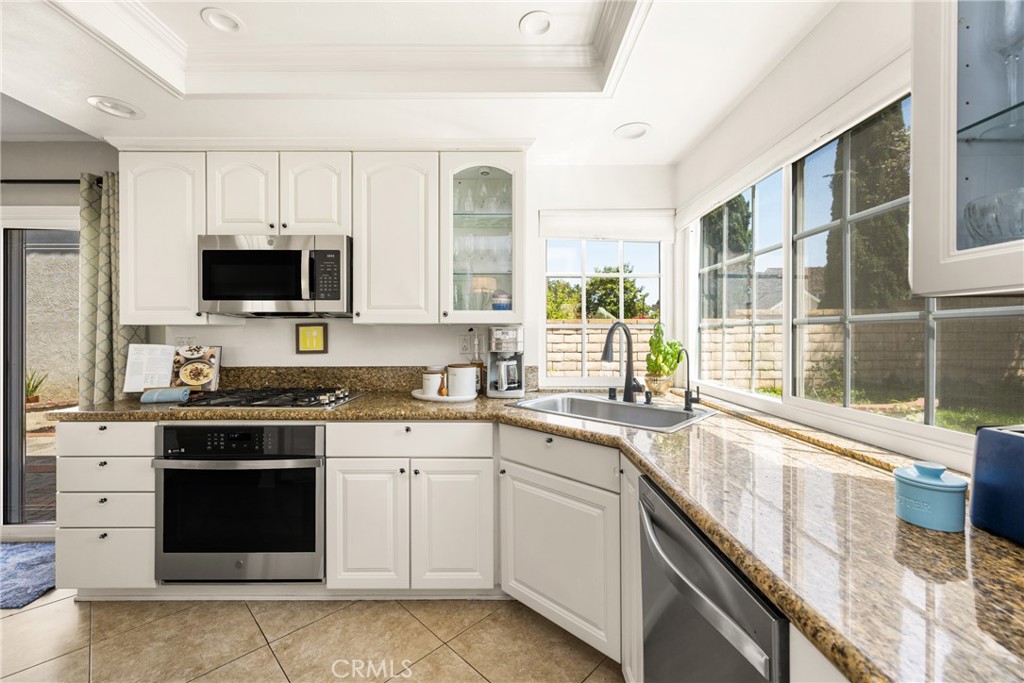 9 Newmeadow Irvine, CA 92614 - Photo 12 of 36 a kitchen with stainless steel appliances granite countertop a stove and a sink