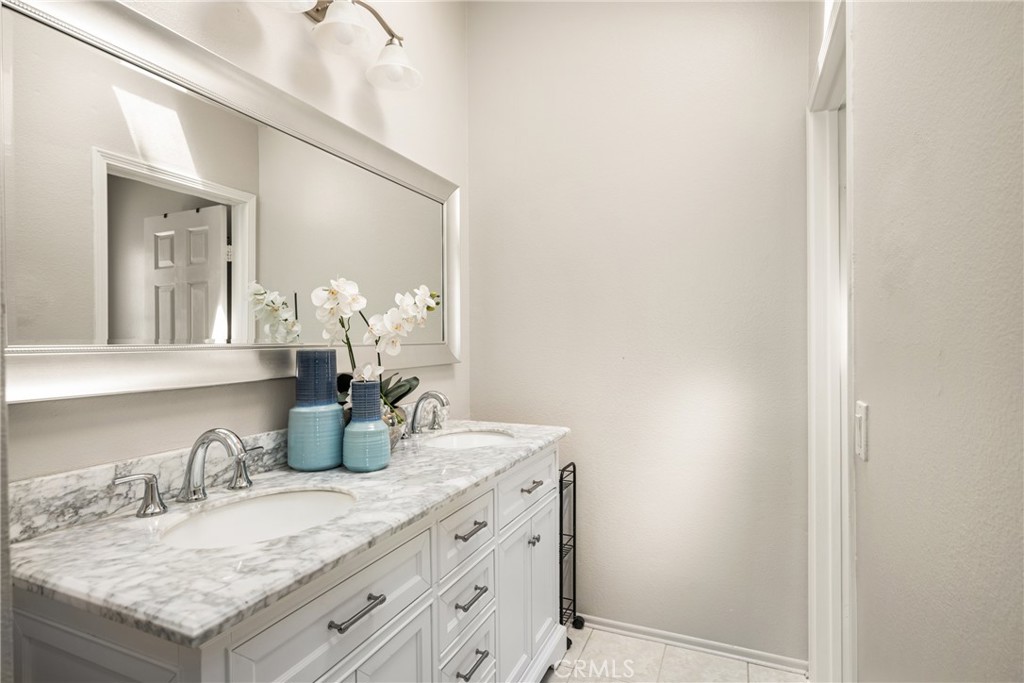 9 Newmeadow Irvine, CA 92614 - Photo 20 of 36 a bathroom with a granite countertop sink and a mirror
