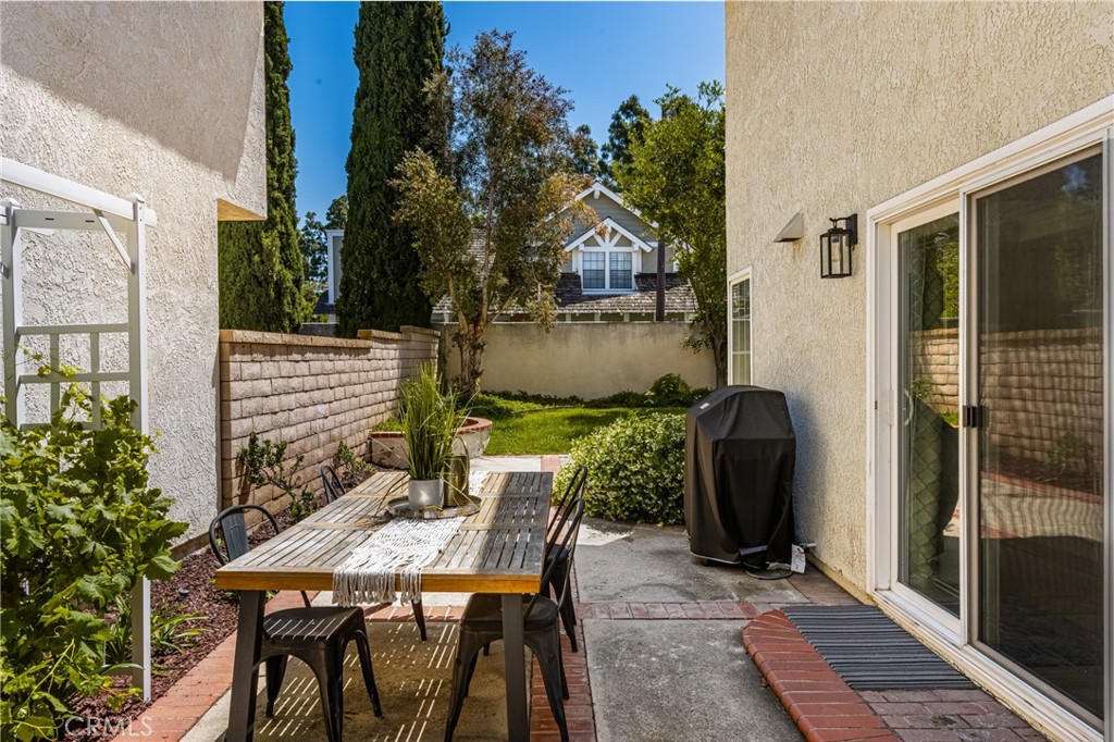 9 Newmeadow Irvine, CA 92614 - Photo 27 of 36 a view of a patio with table and chairs with wooden floor and fence