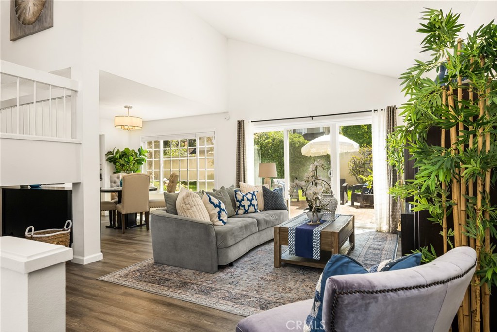 9 Newmeadow Irvine, CA 92614 - Photo 8 of 36 a living room with furniture a large window and a fireplace