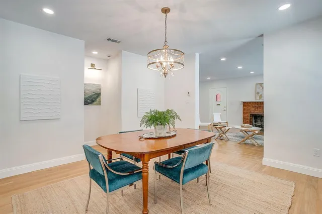 a dining room with furniture a chandelier and wooden floor