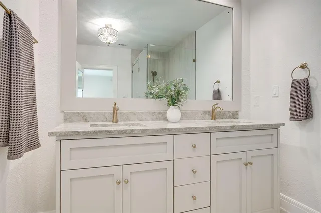 a bathroom with double sink and a mirror