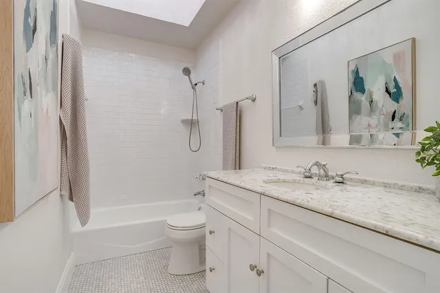 a bathroom with a granite countertop sink toilet and shower