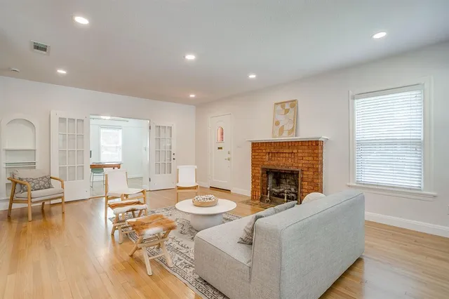 a living room with furniture a fireplace and a floor to ceiling window