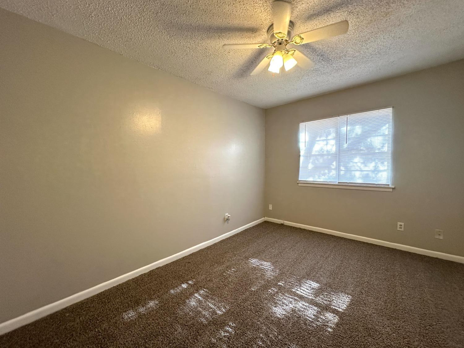 5005 39th Street Lubbock, TX 79414 - Photo 6 of 10 an empty room with windows and fan