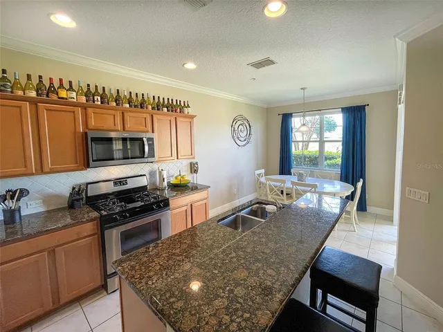 a kitchen with stainless steel appliances granite countertop a stove top oven a sink dishwasher and cabinets with wooden floor