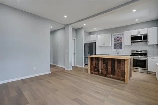 a kitchen with stainless steel appliances a refrigerator and a stove top oven