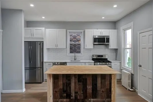 a kitchen with a refrigerator a microwave a sink and cabinets