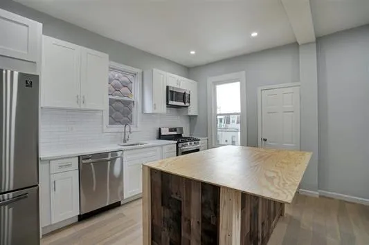 a kitchen with a stove a sink and a refrigerator