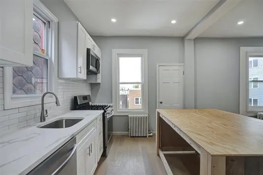 a kitchen that has a sink a stove and cabinets