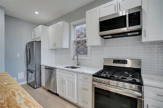 a kitchen with stainless steel appliances a stove a microwave and a sink