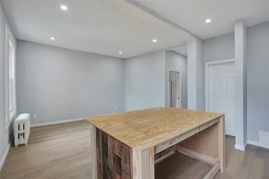 a kitchen with a wooden floor and chandelier