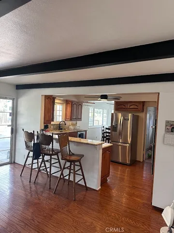 a kitchen with stainless steel appliances wooden floor and dining table
