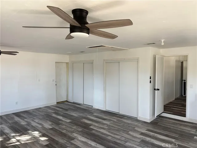 a view of a livingroom with wooden floor and ceiling fan