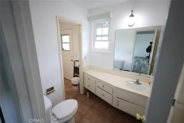 a bathroom with a double vanity sink toilet and mirror