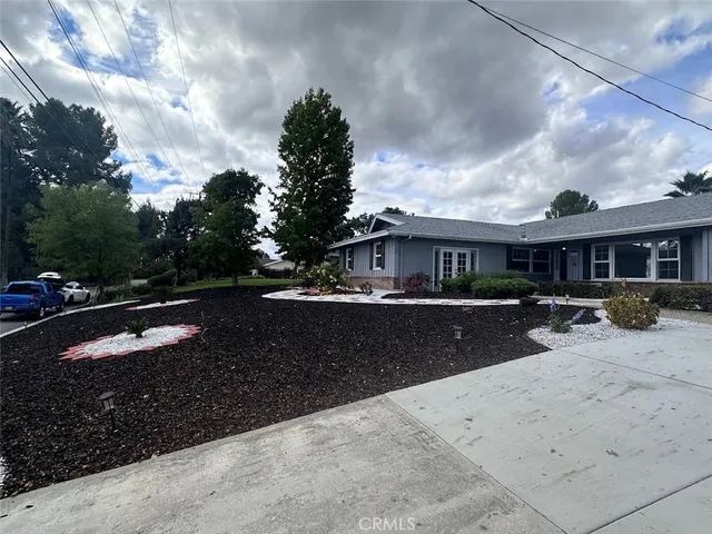a front view of a house with yard and large trees