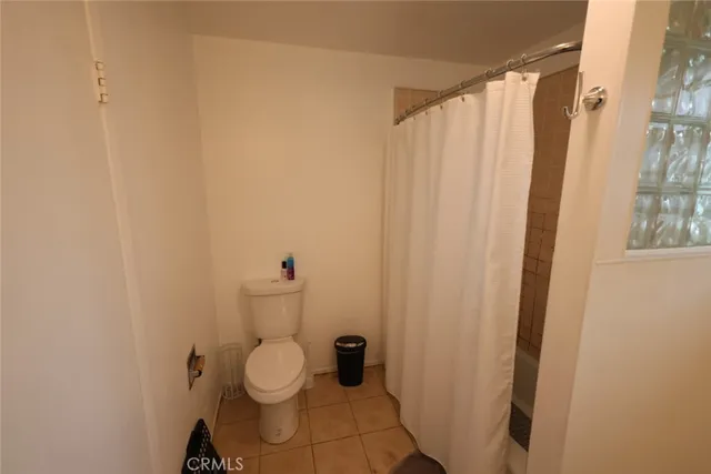 a bathroom with a toilet and a shower curtain