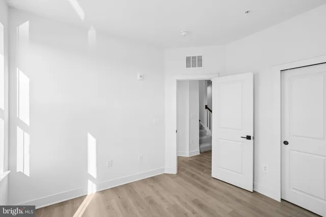 an empty room with wooden floor and closet