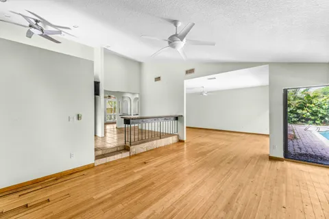 a view of a room with a ceiling fan and wooden floor