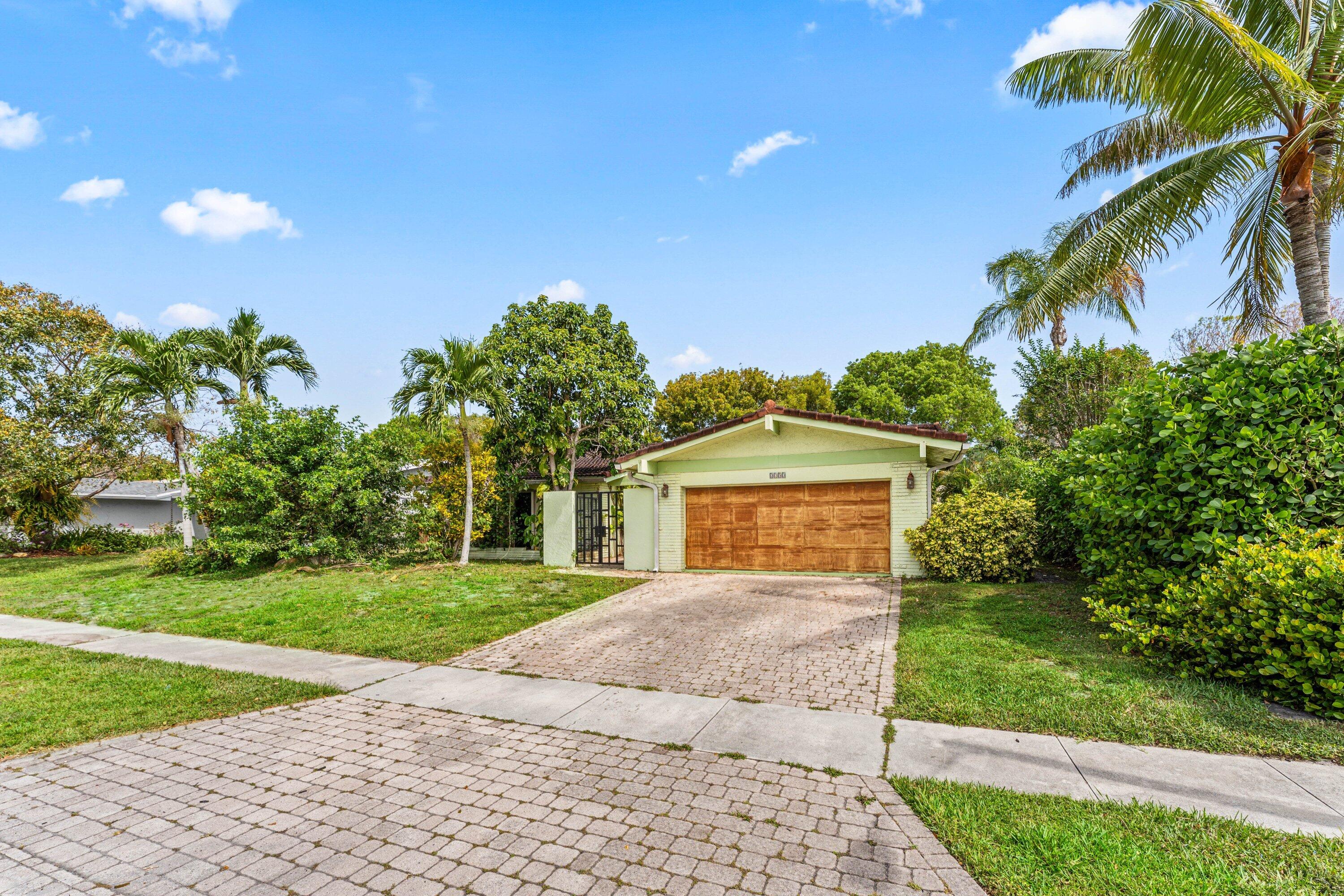 2753 Northwest 34th Street Boca Raton, FL 33434 - Photo 2 of 41 a front view of a house with a yard and garage