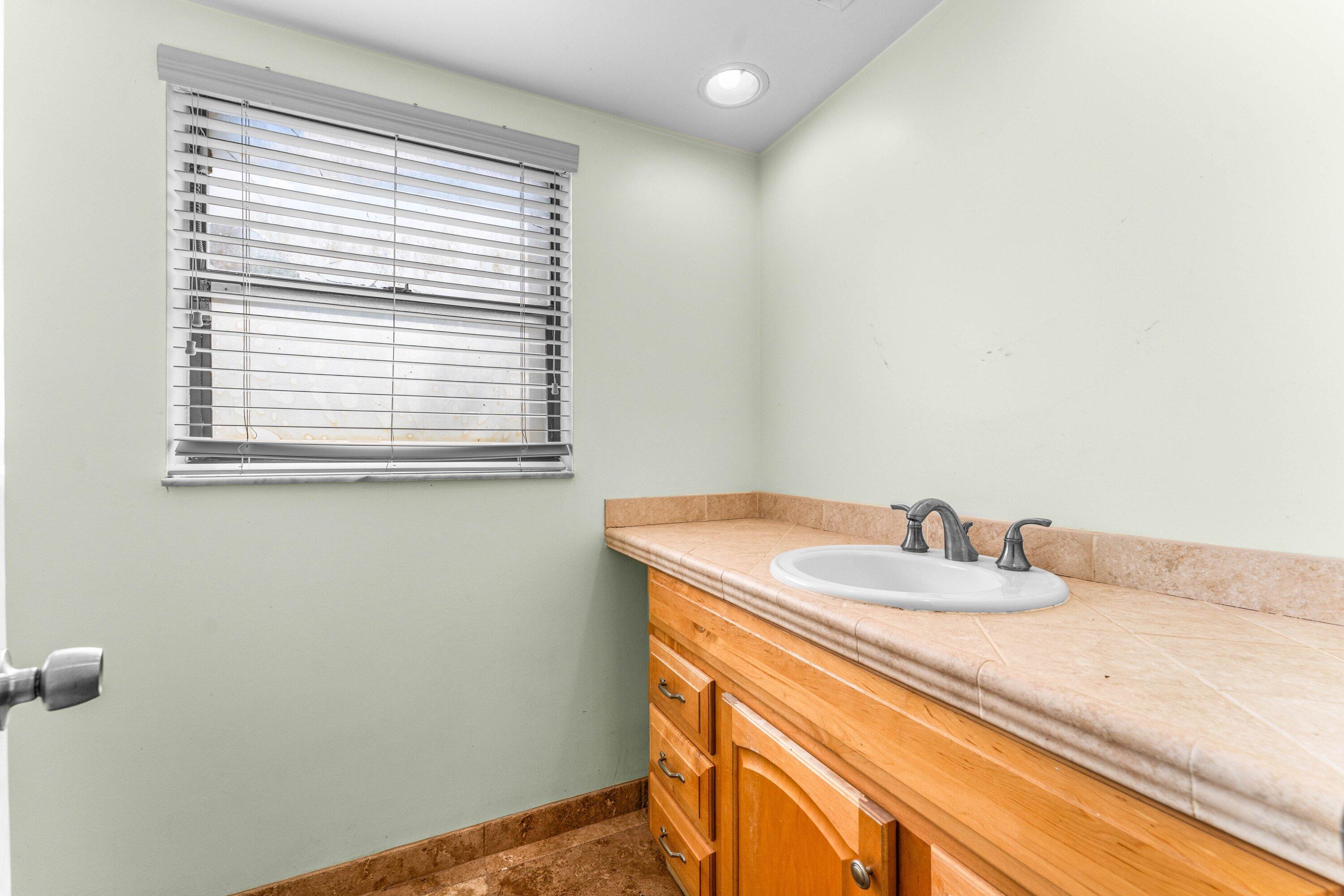 2753 Northwest 34th Street Boca Raton, FL 33434 - Photo 27 of 41 a bathroom with a granite countertop sink and a vanity