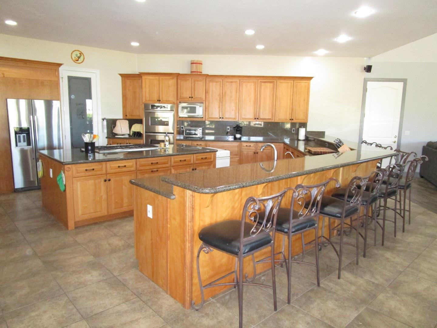 1320 Spring Grove Road Hollister, CA 95023 - Photo 4 of 51 a large dining hall with stainless steel appliances granite countertop a table and chairs