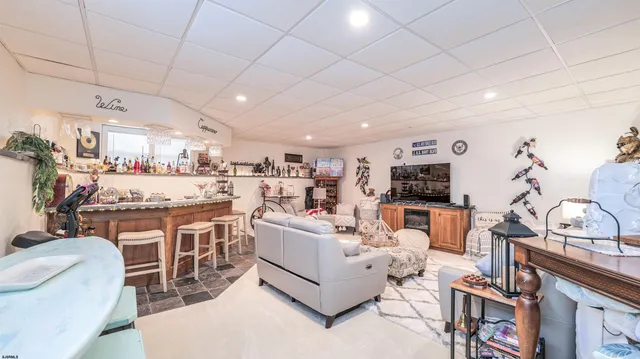 a living room with furniture a flat screen tv and kitchen view