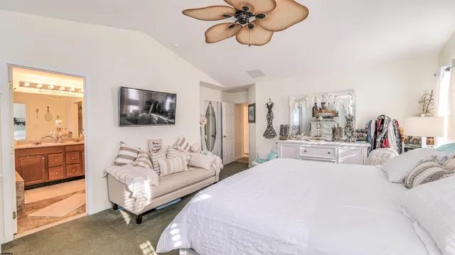 a bedroom with a bed and a flat tv screen on dresser